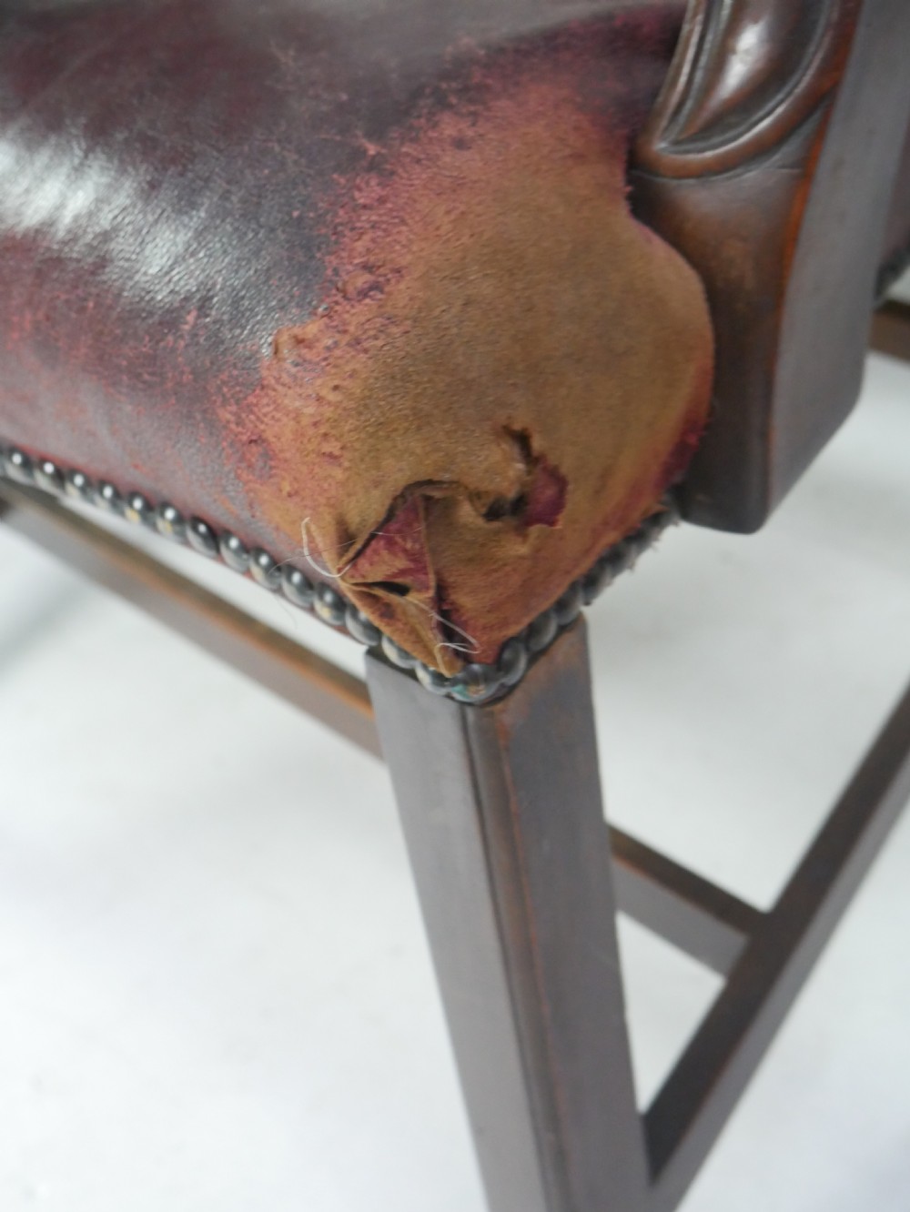 A set of eight mahogany Chippendale style dining chairs featuring pierced splat backs, square legs with stretchers, and burgundy leather seats trimmed with brass studs. View VII