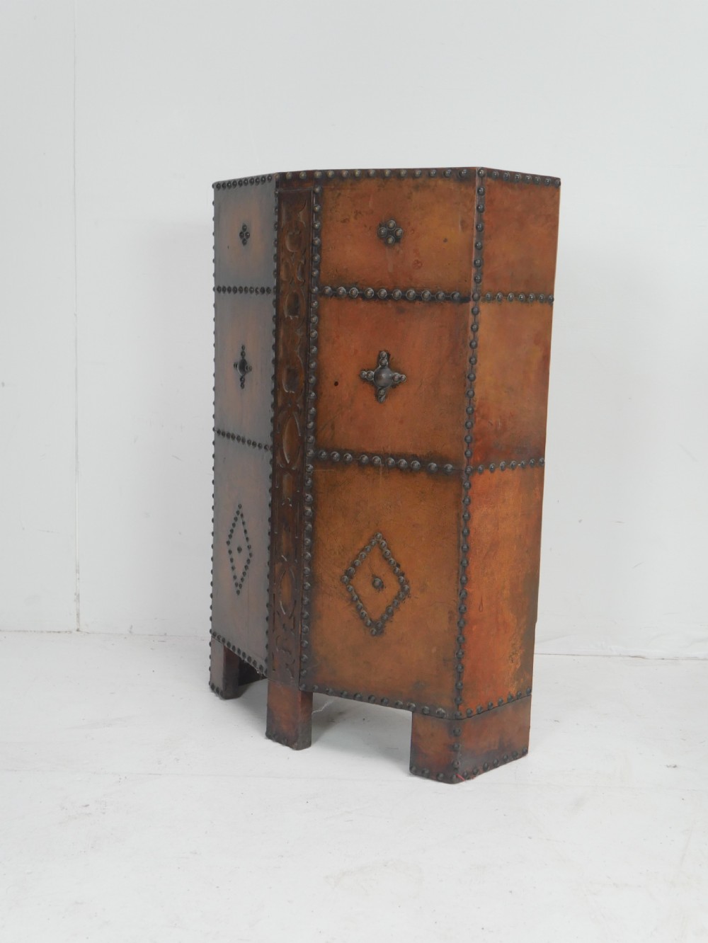 A tall, angular brown leather umbrella stand crafted with studded metal borders and decorative embossed detailing. View III