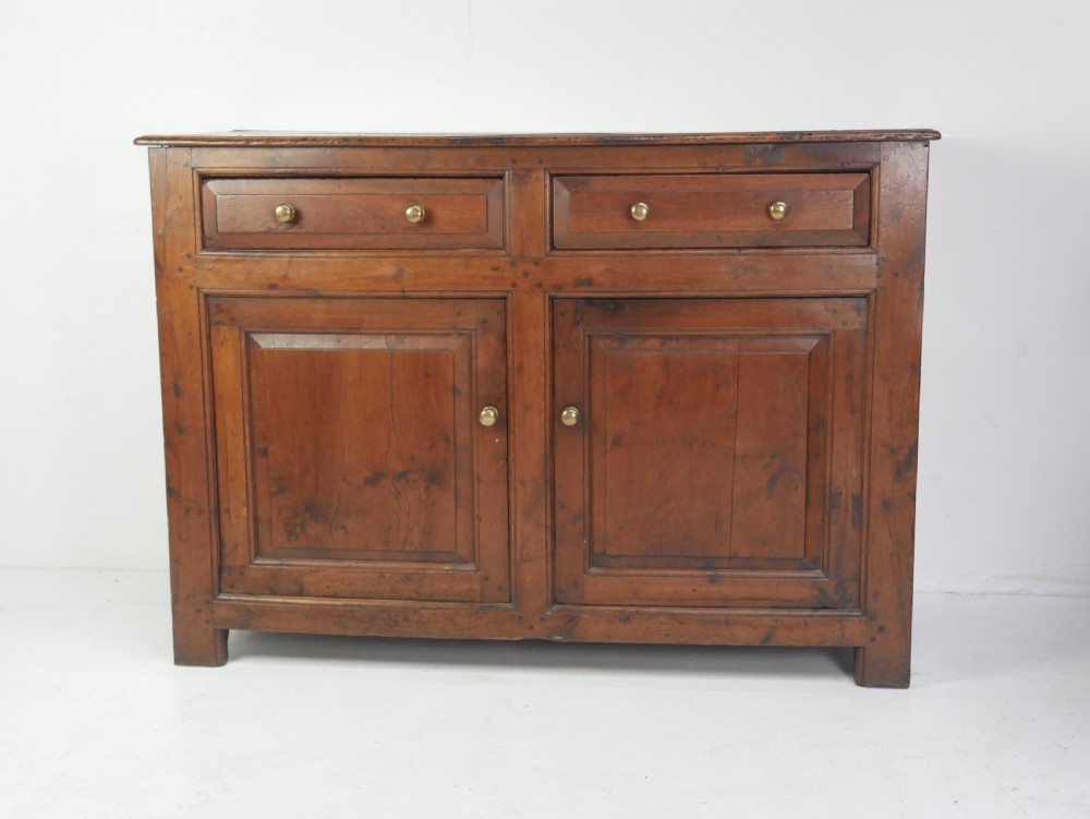 A Georgian oak dresser base featuring two top drawers above two fielded panel cupboard doors fitted with small brass knobs. View III