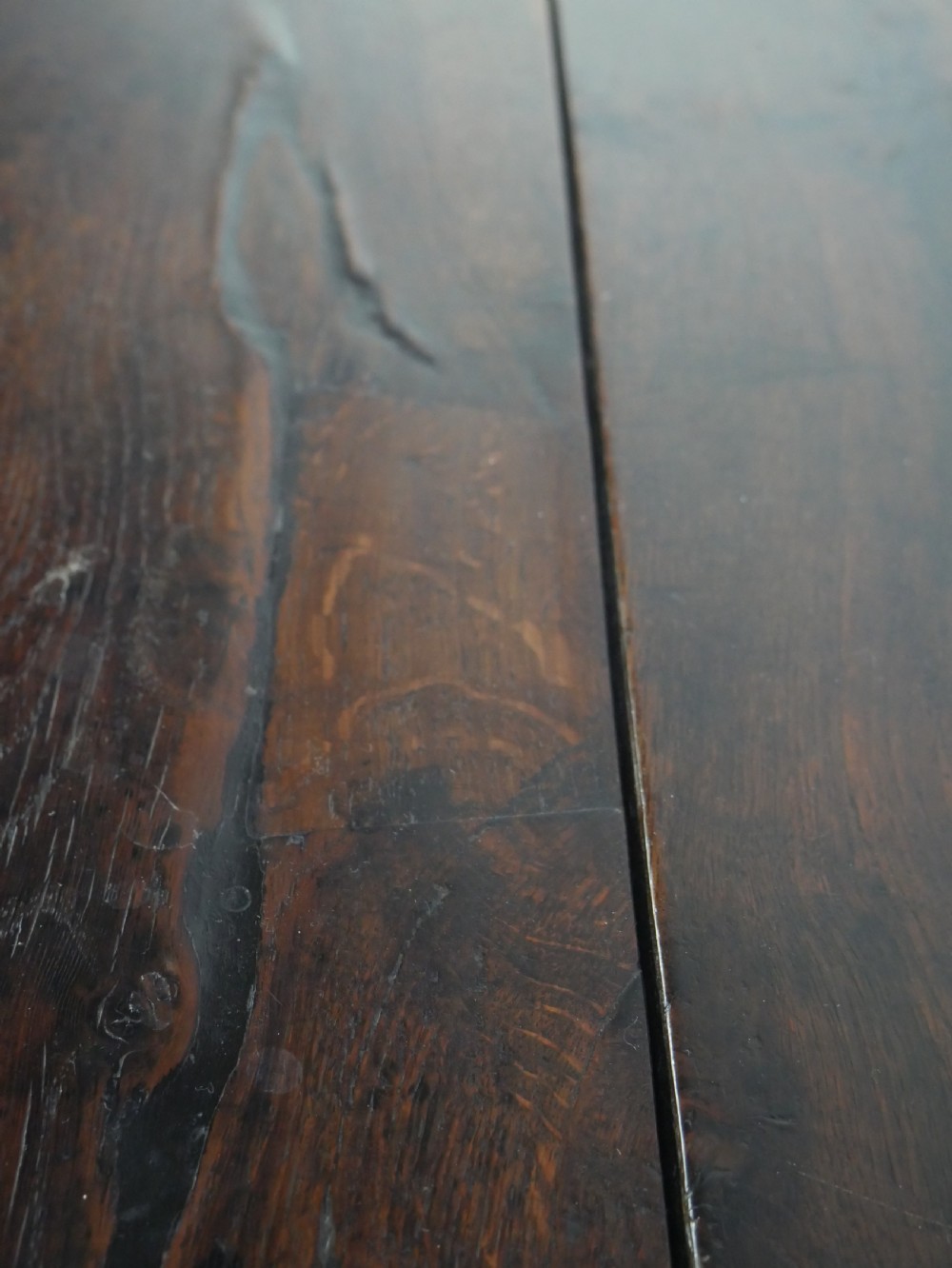 A Georgian oak dresser base featuring two top drawers above two fielded panel cupboard doors fitted with small brass knobs. View XI