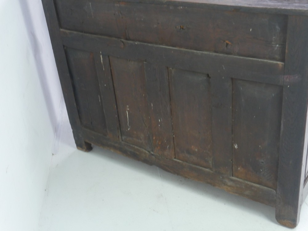 A Georgian oak dresser base featuring two top drawers above two fielded panel cupboard doors fitted with small brass knobs. View XVII