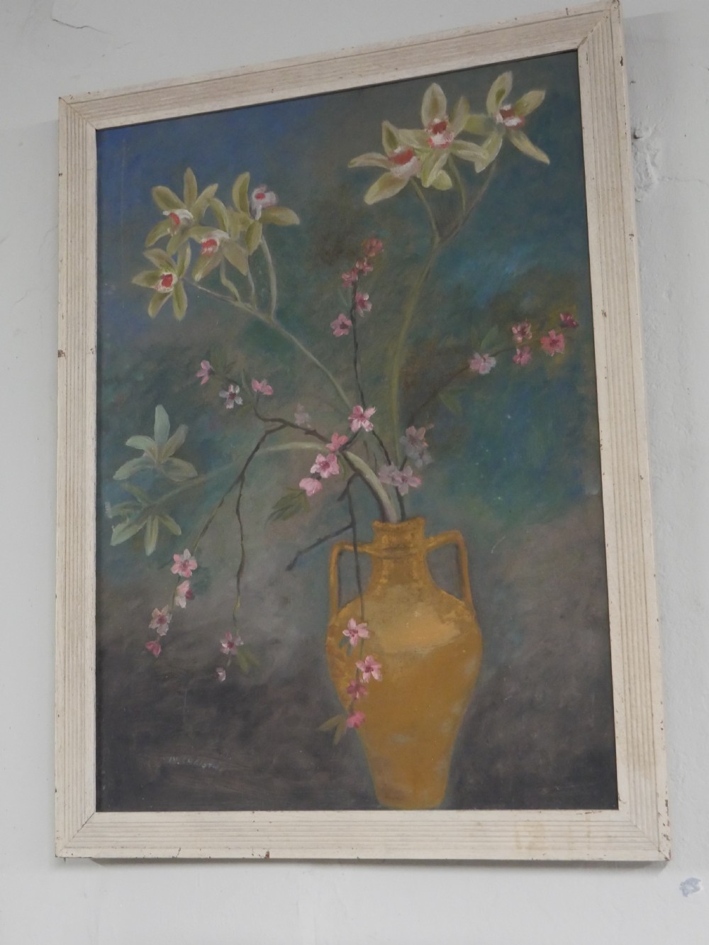 A 1960s framed floral still life painting depicting green orchids and pink blossoms in a yellow two-handled vase against a dark blue background. View VII