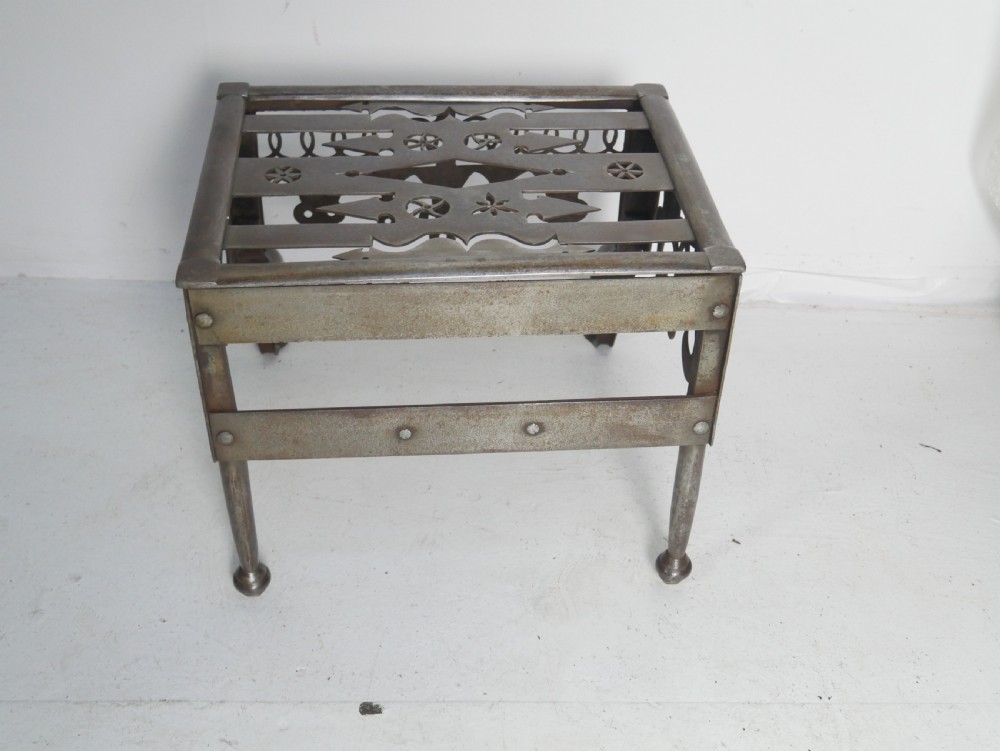 An antique pierced steel hearth footman featuring cabriole front legs, pad feet, and a fretted top. View VI