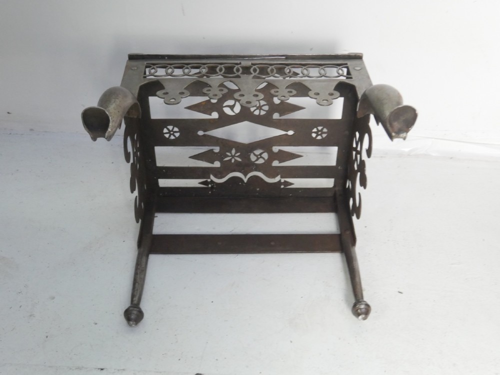 An antique pierced steel hearth footman featuring cabriole front legs, pad feet, and a fretted top. View XI