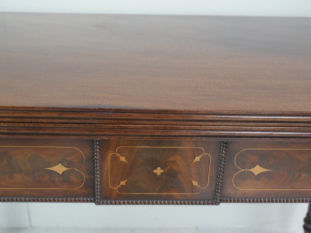 A Regency mahogany fold-over side table with an inlaid decorative frieze and four turned legs. View II
