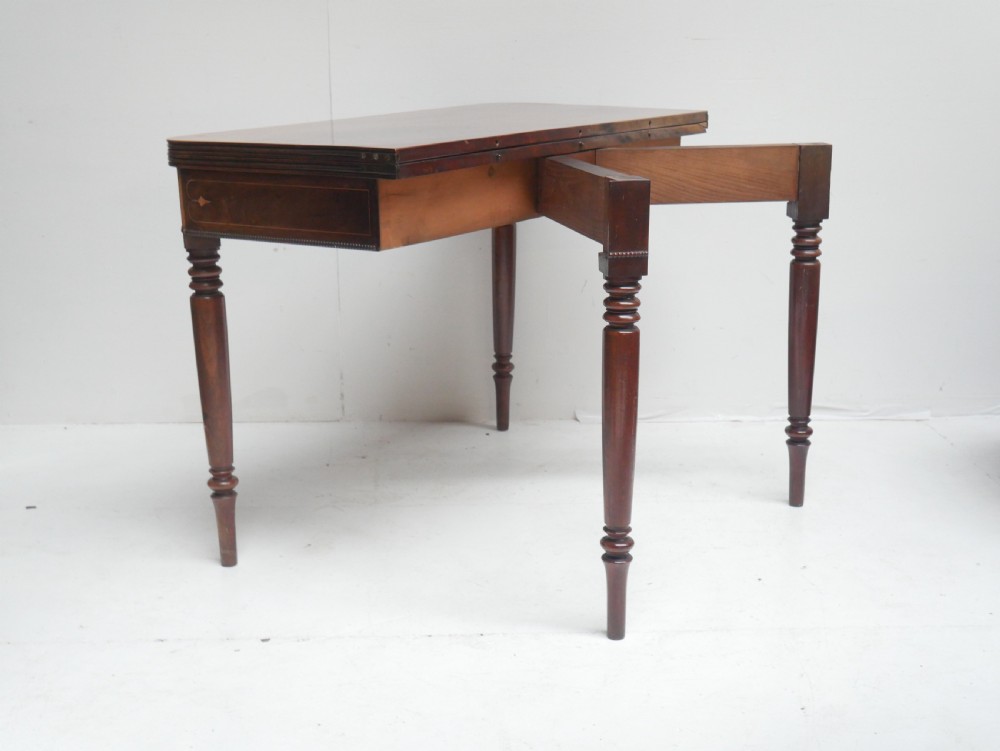 A Regency mahogany fold-over side table with an inlaid decorative frieze and four turned legs. View IX