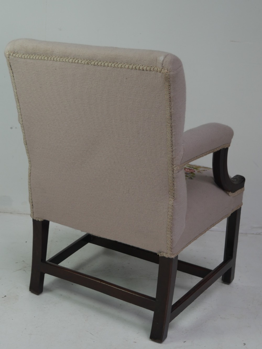 A Georgian Gainsborough armchair with dark carved mahogany legs, upholstered in beige needlepoint tapestry featuring a central pastoral scene and floral borders. View IX