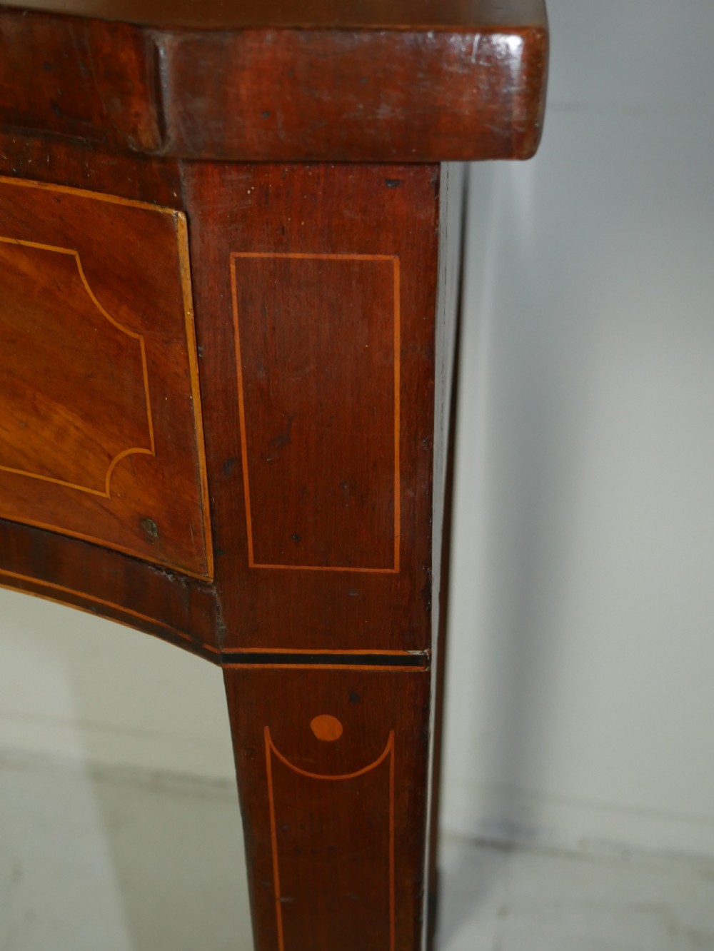 A Scottish Georgian mahogany sideboard featuring a raised stage top superstructure, stringing inlay, three drawer fronts with brass drop handles, and square tapered legs. View III