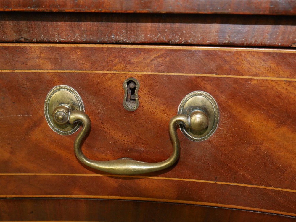 A Scottish Georgian mahogany sideboard featuring a raised stage top superstructure, stringing inlay, three drawer fronts with brass drop handles, and square tapered legs. View V