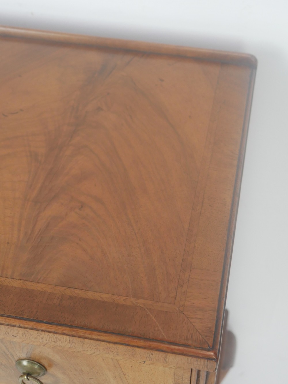 A Queen Anne revival walnut bedside cabinet featuring two top drawers, a two-door cupboard, and tall cabriole legs. View VI