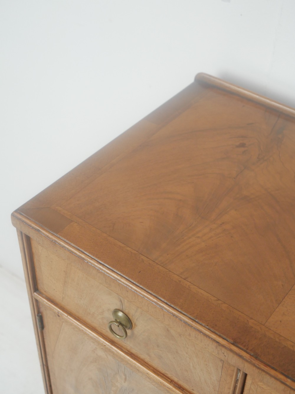 A Queen Anne revival walnut bedside cabinet featuring two top drawers, a two-door cupboard, and tall cabriole legs. View VII