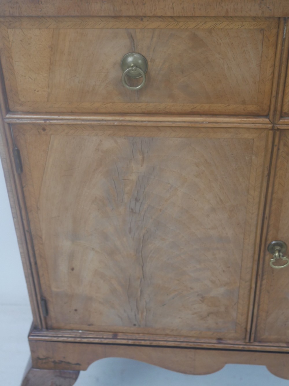 A Queen Anne revival walnut bedside cabinet featuring two top drawers, a two-door cupboard, and tall cabriole legs. View VIII
