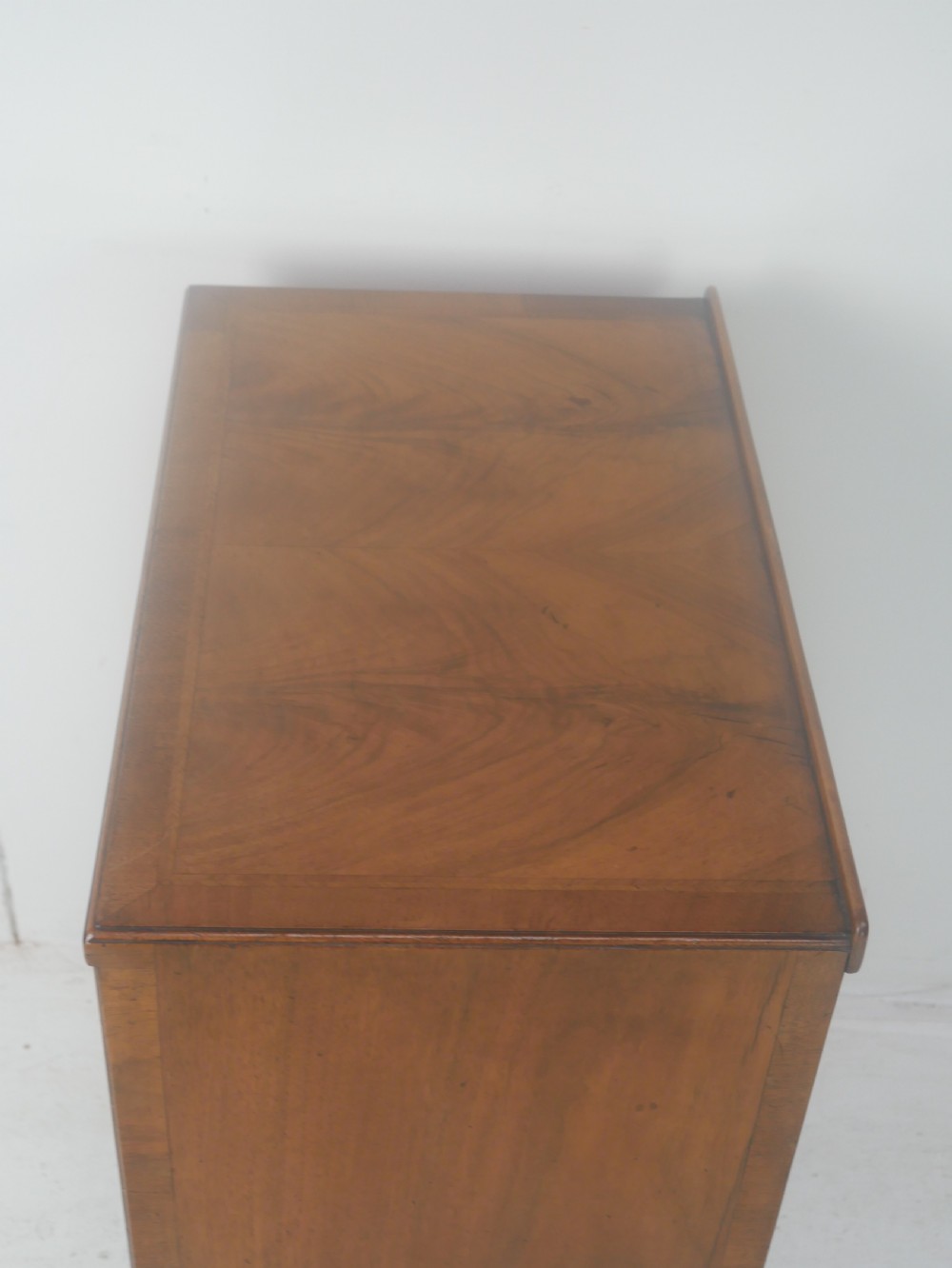 A Queen Anne revival walnut bedside cabinet featuring two top drawers, a two-door cupboard, and tall cabriole legs. View XI