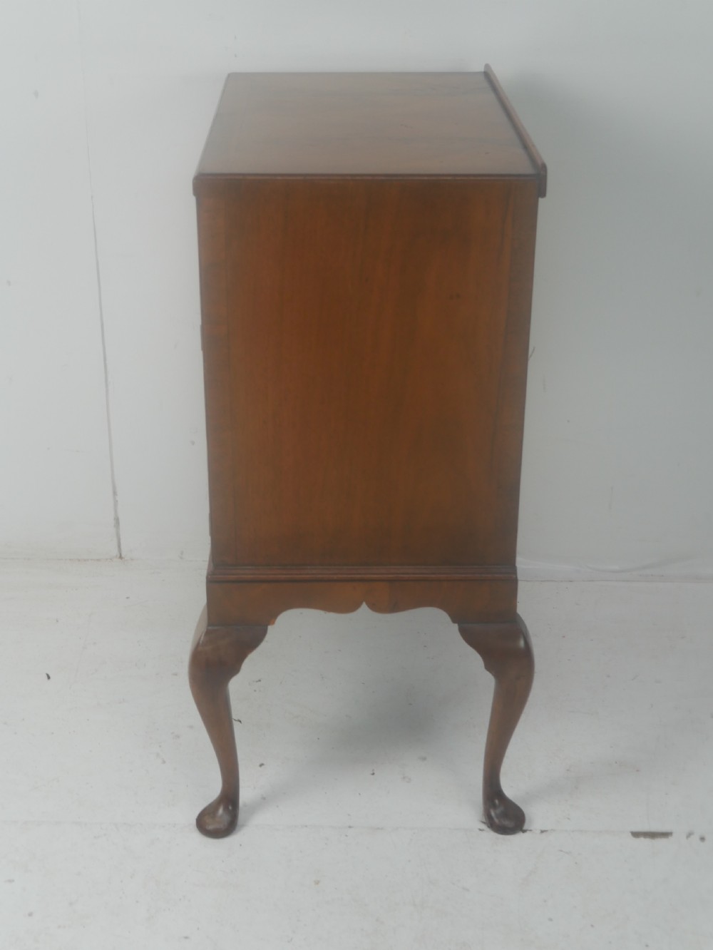 A Queen Anne revival walnut bedside cabinet featuring two top drawers, a two-door cupboard, and tall cabriole legs. View XII