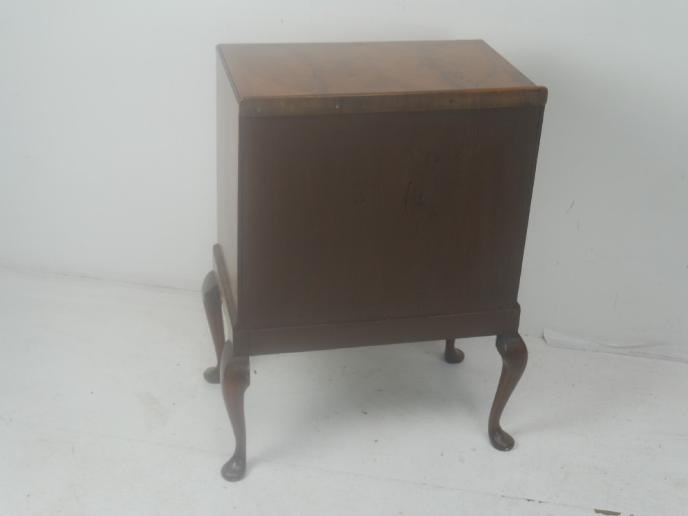 A Queen Anne revival walnut bedside cabinet featuring two top drawers, a two-door cupboard, and tall cabriole legs. View XIII