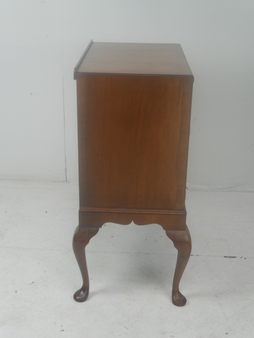 A Queen Anne revival walnut bedside cabinet featuring two top drawers, a two-door cupboard, and tall cabriole legs. View XIV