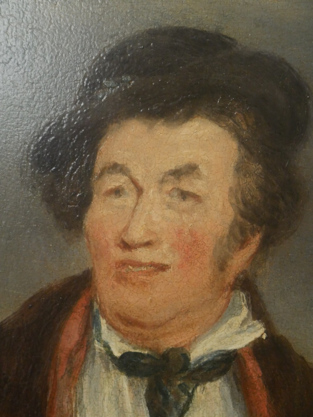 An oil portrait on canvas depicting a male Northumbrian piper holding smallpipes, housed in an ornate carved gilt frame. View II