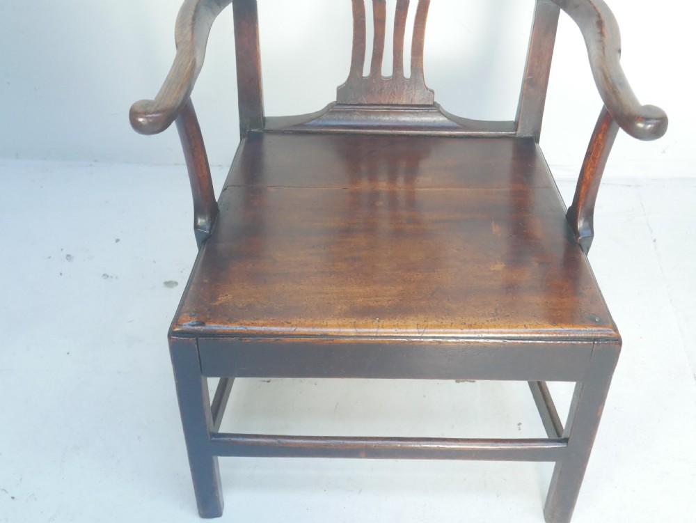A dark wood Georgian country armchair featuring a pierced back splat with a heart motif, solid seat, curved armrests, and a sturdy stretcher base. View II