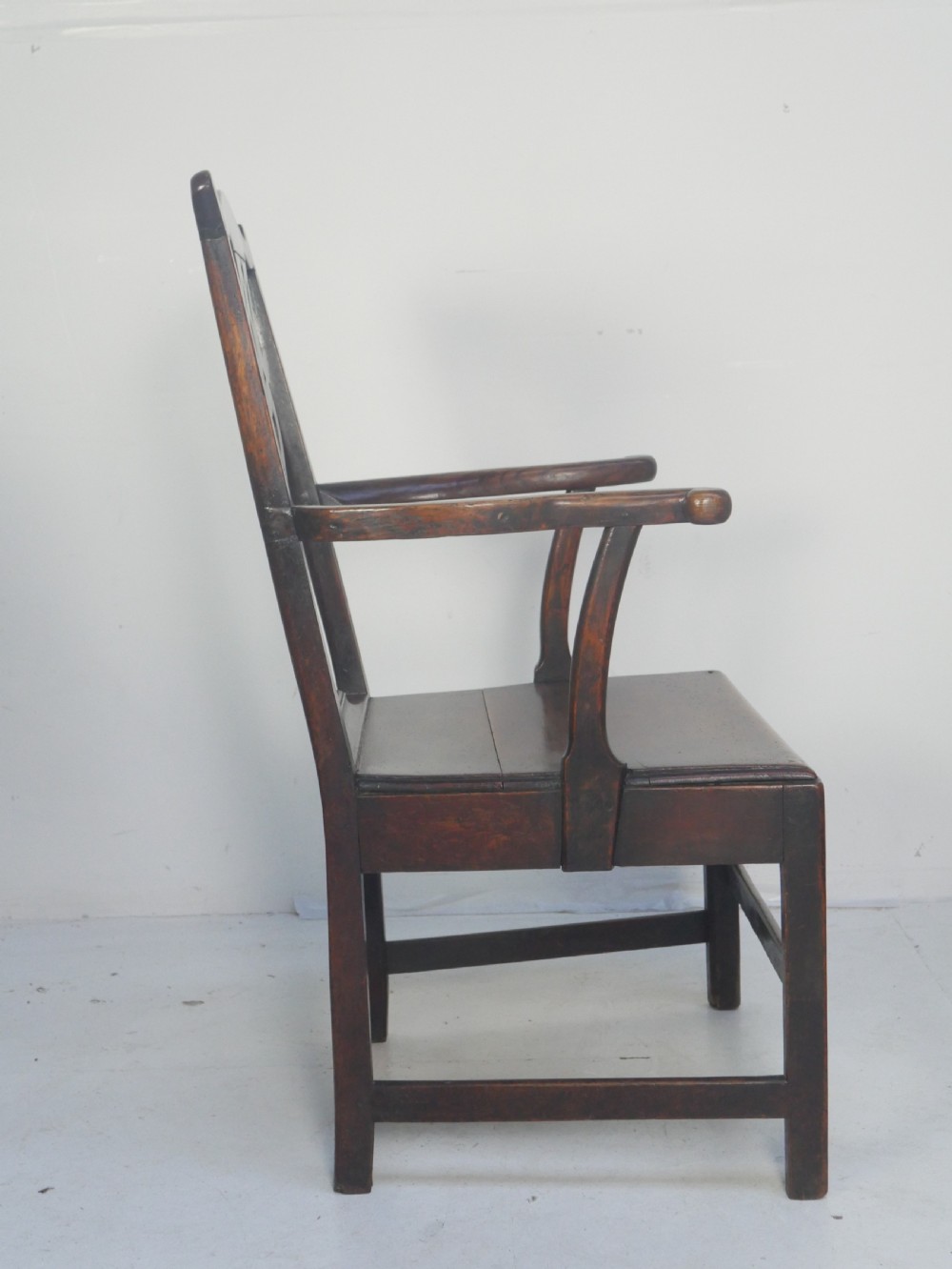 A dark wood Georgian country armchair featuring a pierced back splat with a heart motif, solid seat, curved armrests, and a sturdy stretcher base. View IX