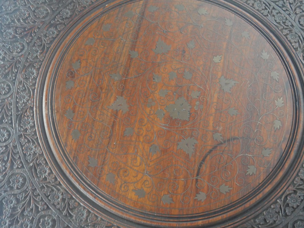 A dark hardwood octagonal side table featuring openwork fretwork panels carved with foliage motifs and a brass inlaid top surface. View III