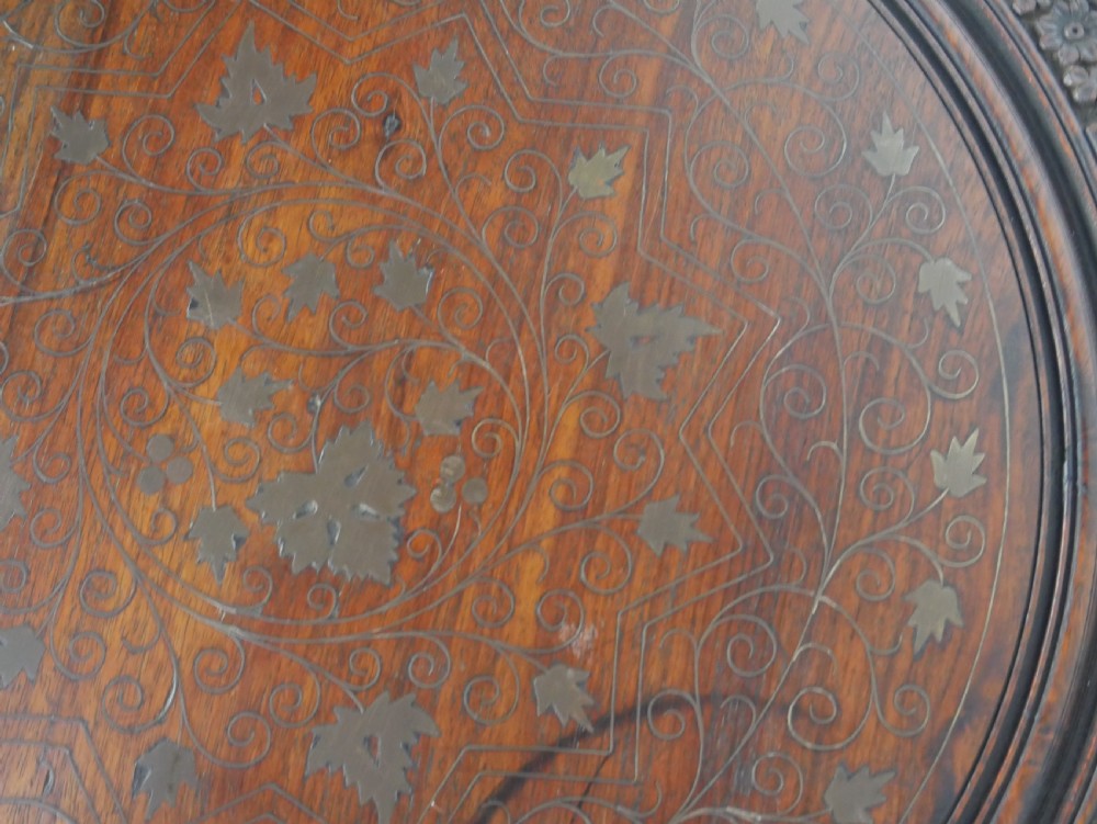 A dark hardwood octagonal side table featuring openwork fretwork panels carved with foliage motifs and a brass inlaid top surface. View IV