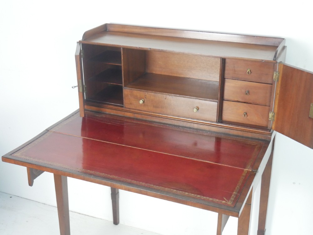A mahogany bonheur de jour writing desk featuring a raised rear cabinet with two small doors and a central niche above a single frieze drawer on square tapered legs. View II