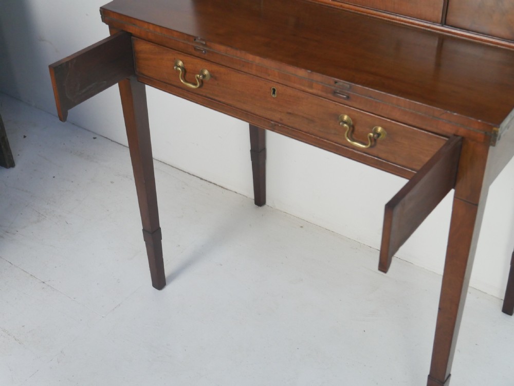 A mahogany bonheur de jour writing desk featuring a raised rear cabinet with two small doors and a central niche above a single frieze drawer on square tapered legs. View III