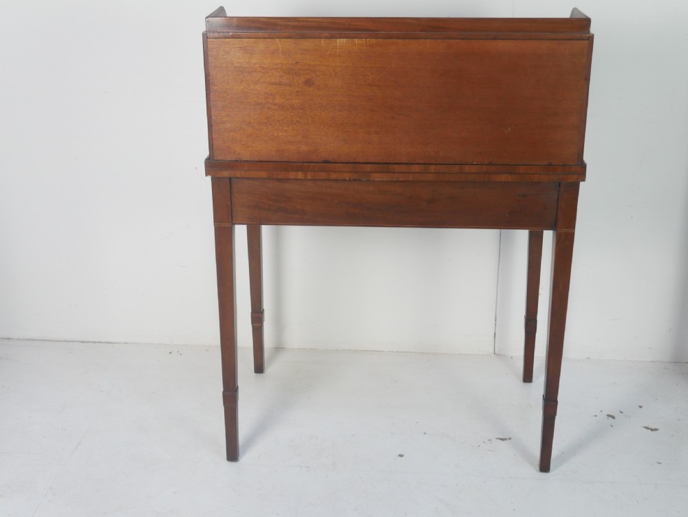A mahogany bonheur de jour writing desk featuring a raised rear cabinet with two small doors and a central niche above a single frieze drawer on square tapered legs. View IX