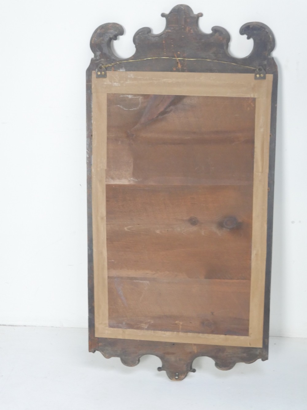 An 18th-century walnut wall mirror featuring a scroll-carved crest and apron, rounded upper corners, and a gilded inner moulding frame. View VIII