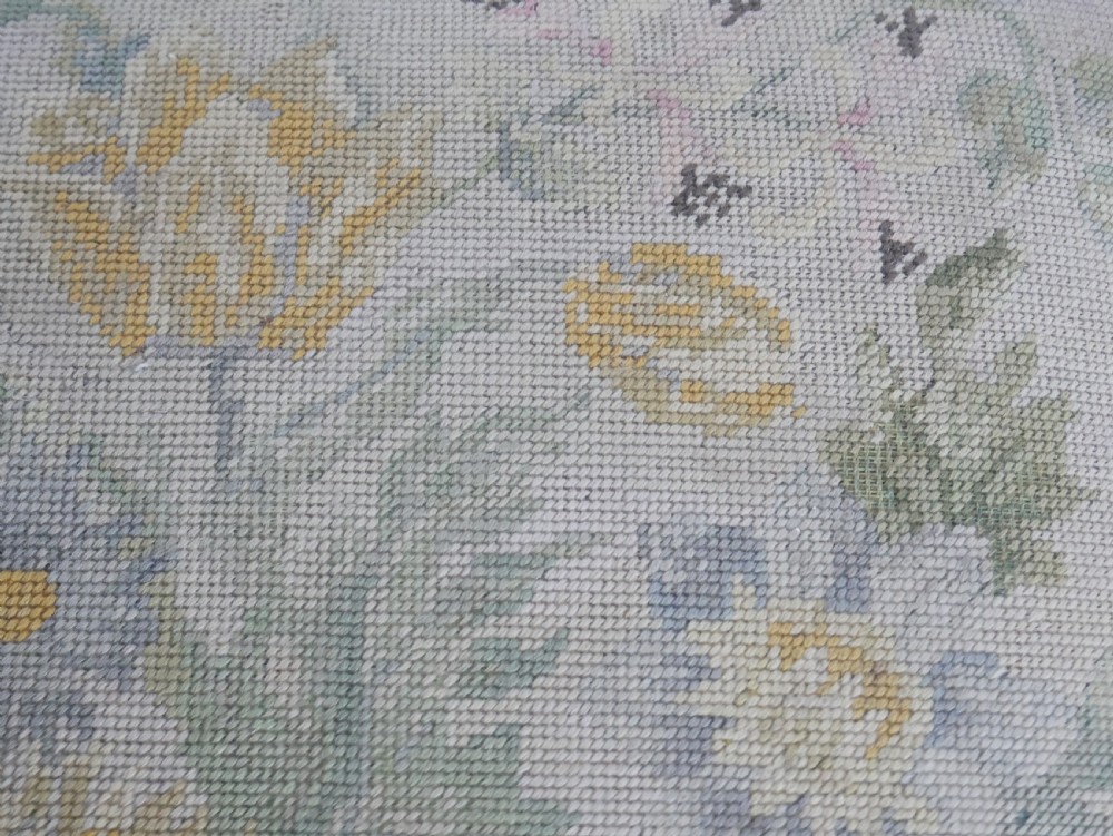 A square upholstered footstool featuring floral needlepoint fabric, carved cabriole legs, and claw and ball feet. View III