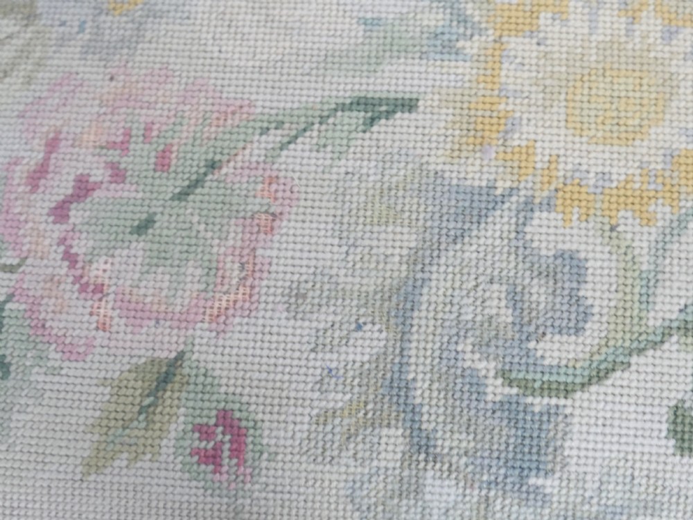 A square upholstered footstool featuring floral needlepoint fabric, carved cabriole legs, and claw and ball feet. View IV