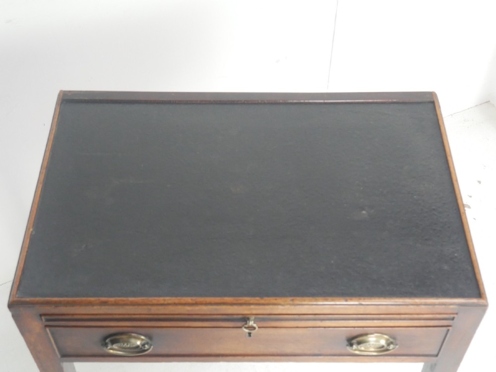 A Georgian mahogany side table featuring a dark leather inset top, frieze drawer with brass handles, and slender tapered legs. View IX