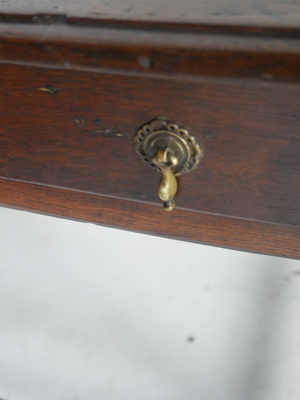 A dark brown Georgian oak side table featuring a single drawer with brass drop handles, turned legs, and a sturdy lower perimeter stretcher. View VI