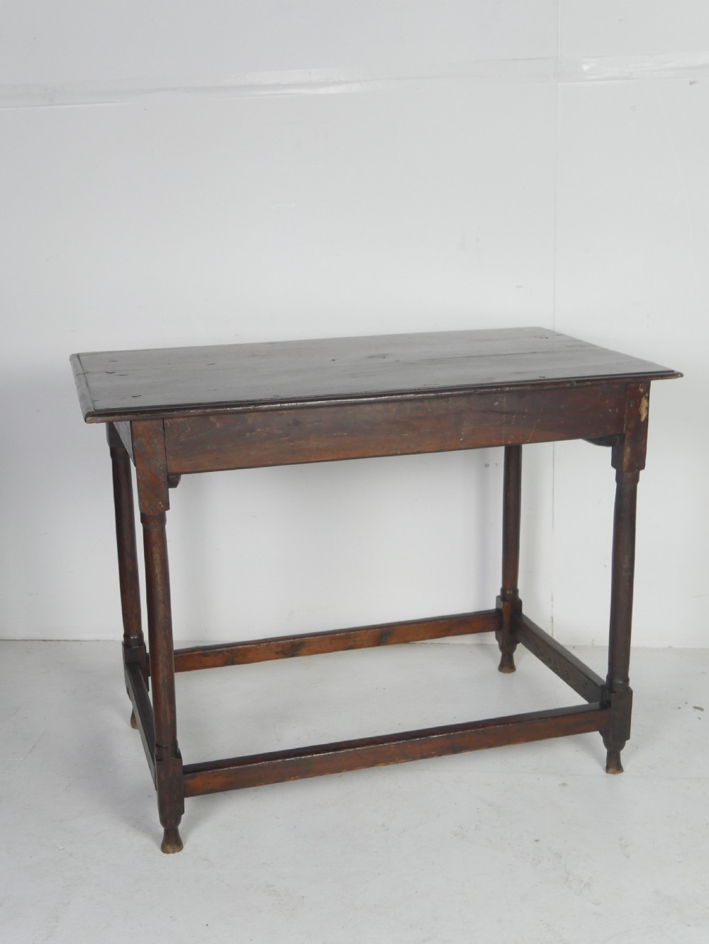 A dark brown Georgian oak side table featuring a single drawer with brass drop handles, turned legs, and a sturdy lower perimeter stretcher. View XI