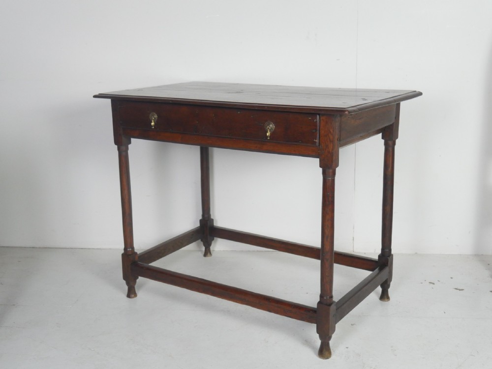 A dark brown Georgian oak side table featuring a single drawer with brass drop handles, turned legs, and a sturdy lower perimeter stretcher. View XIV