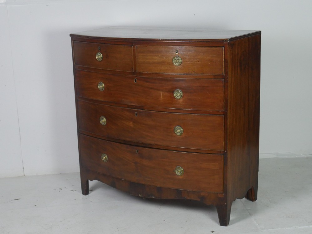 A Georgian mahogany bow-front chest of drawers featuring two short drawers over three long graduated drawers with circular brass drop handles.