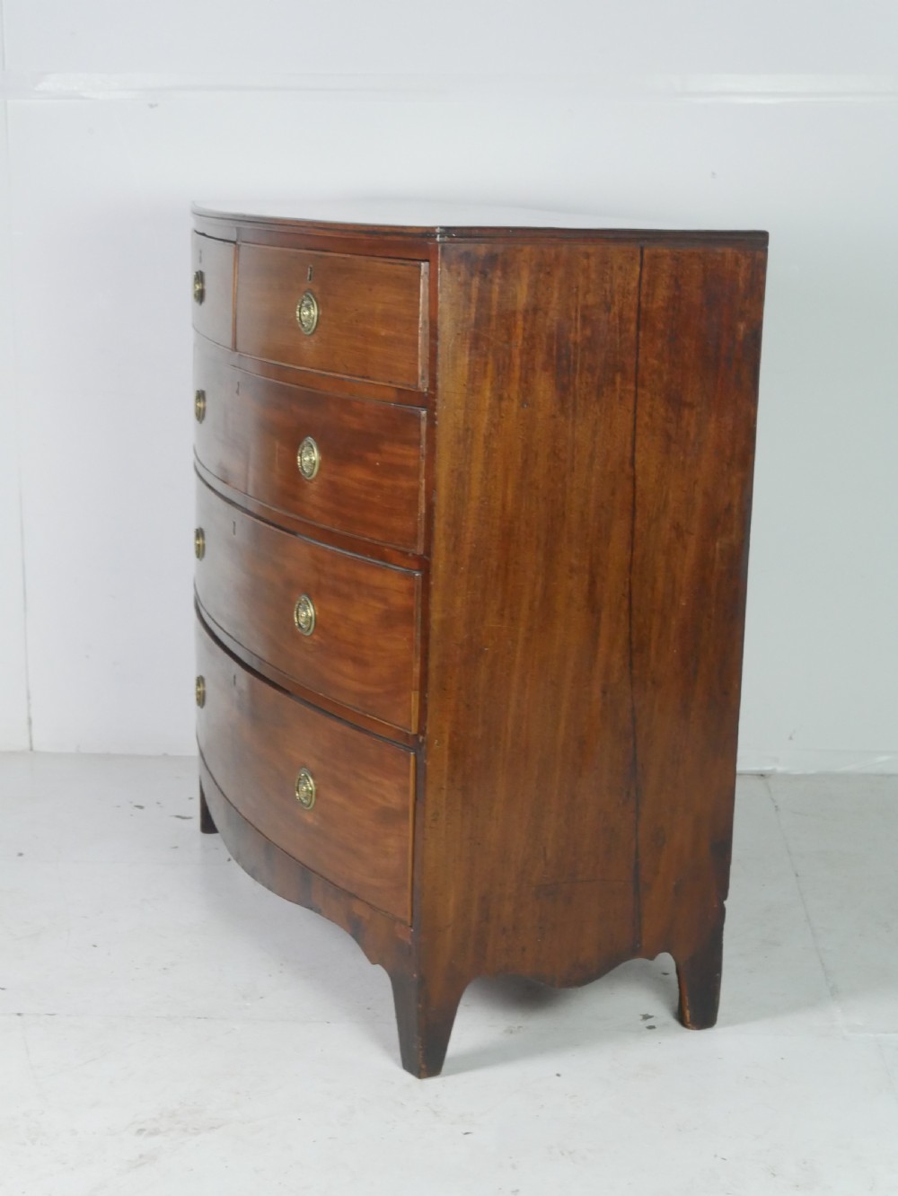 A Georgian mahogany bow-front chest of drawers featuring two short drawers over three long graduated drawers with circular brass drop handles. View III