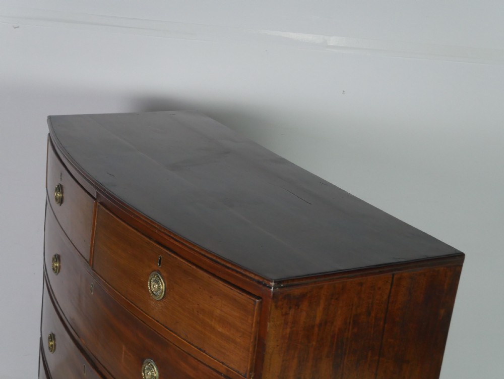 A Georgian mahogany bow-front chest of drawers featuring two short drawers over three long graduated drawers with circular brass drop handles. View IV