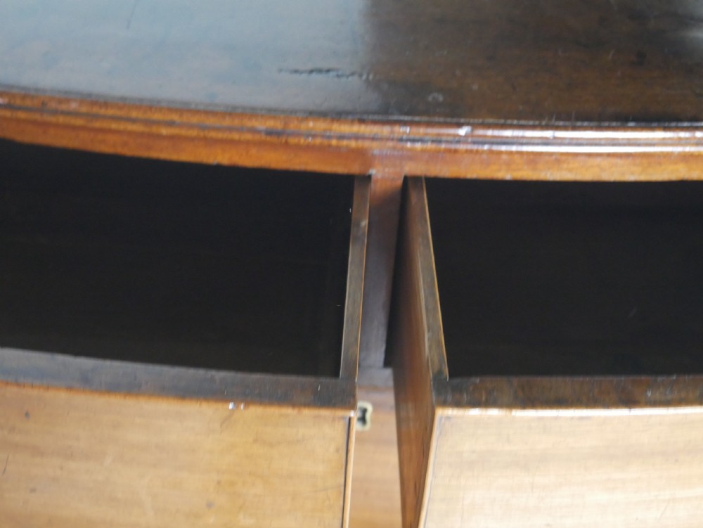 A Georgian mahogany bow-front chest of drawers featuring two short drawers over three long graduated drawers with circular brass drop handles. View V