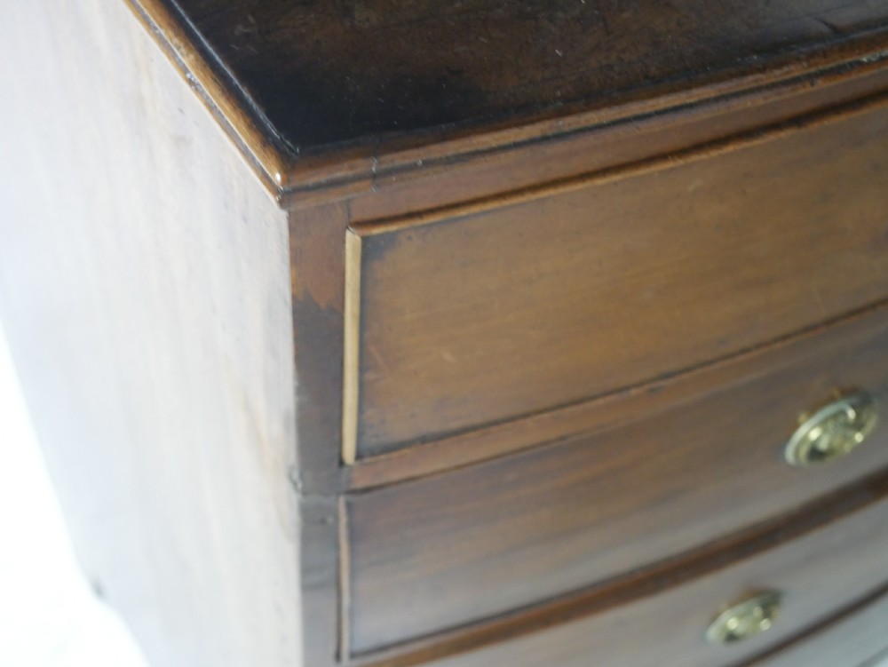 A Georgian mahogany bow-front chest of drawers featuring two short drawers over three long graduated drawers with circular brass drop handles. View VIII