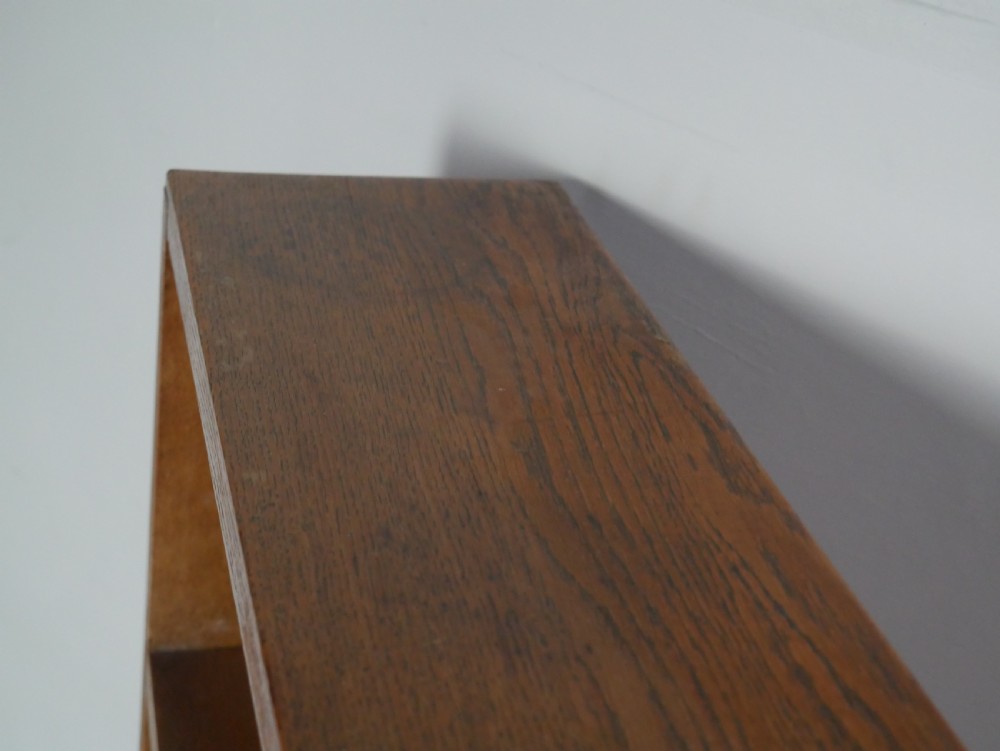 A wide wooden open bookcase made of light oak with four horizontal shelves and a simple plinth base. View IV