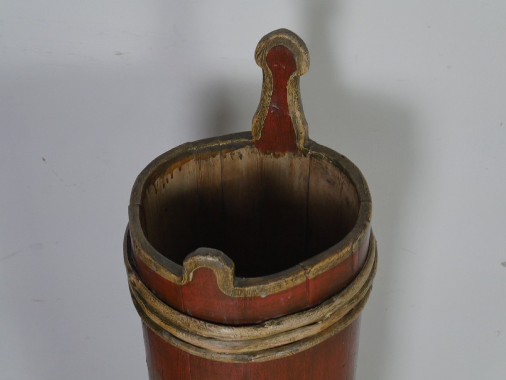 A tall, cylindrical red-painted wooden umbrella stand featuring hand-painted floral motifs and raised wooden banding. View II