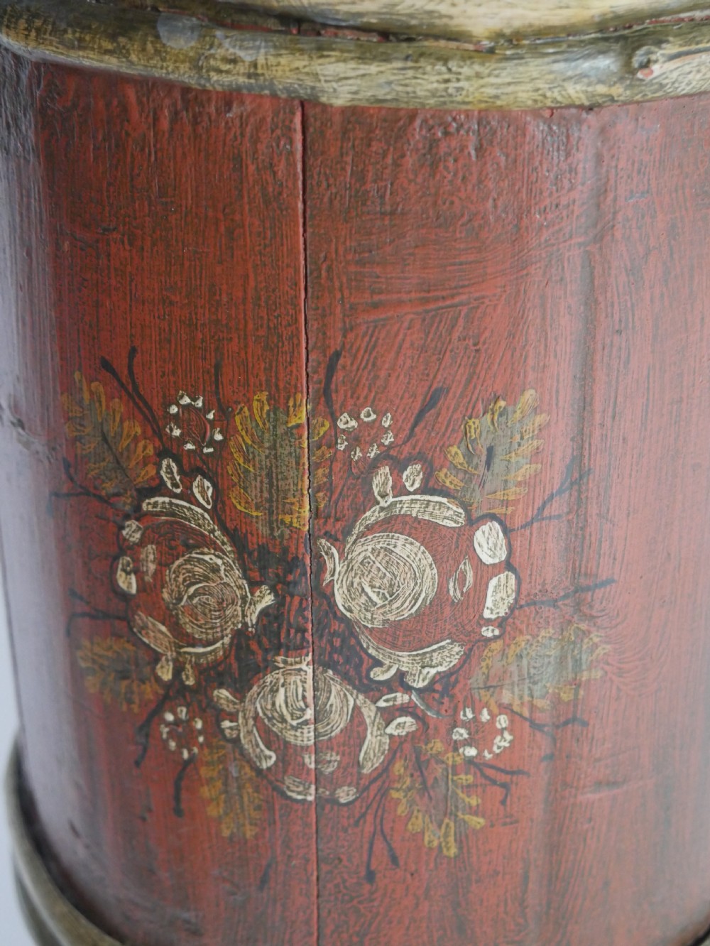 A tall, cylindrical red-painted wooden umbrella stand featuring hand-painted floral motifs and raised wooden banding. View IV