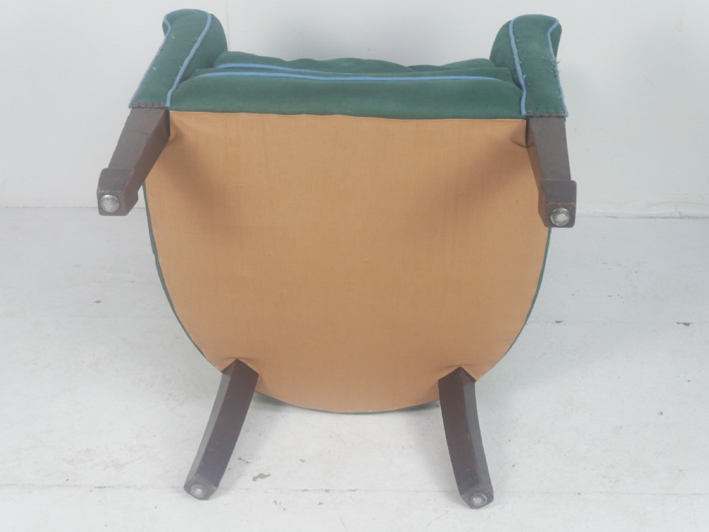 A forest green upholstered barrel back armchair with vertical channel tufting, light blue contrast piping, and dark tapered square legs. View IV