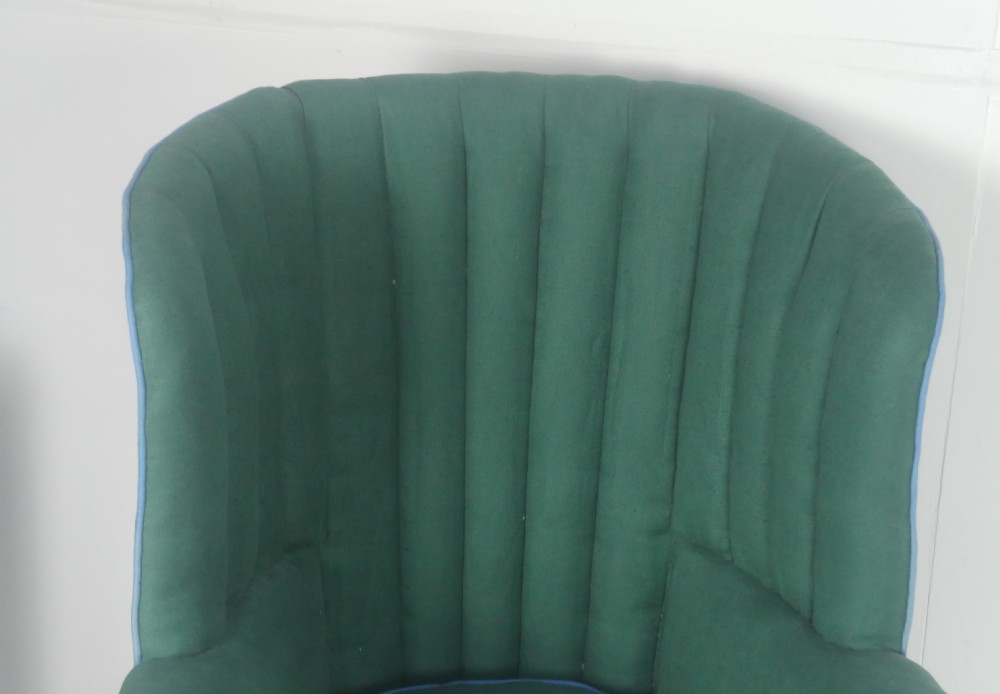 A forest green upholstered barrel back armchair with vertical channel tufting, light blue contrast piping, and dark tapered square legs. View VIII