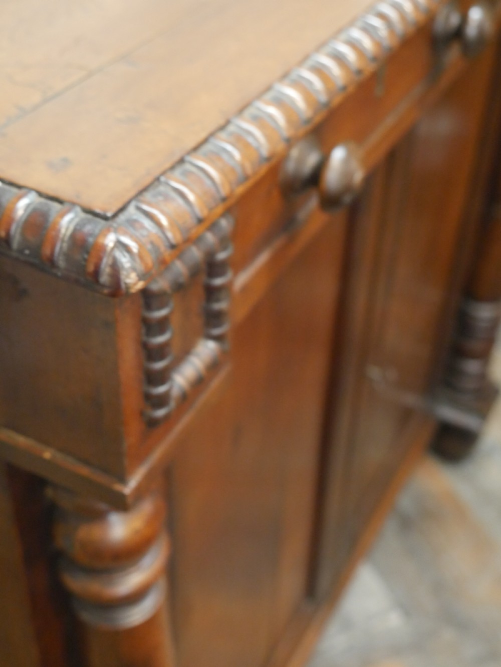A warm brown cedar cupboard featuring two top drawers, twin panelled doors, and carved side columns supported by turned feet. View VIII