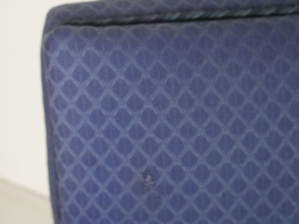 A pair of high-backed armchairs upholstered in patterned blue fabric with rolled arms and turned wooden feet on brass castors. View VII