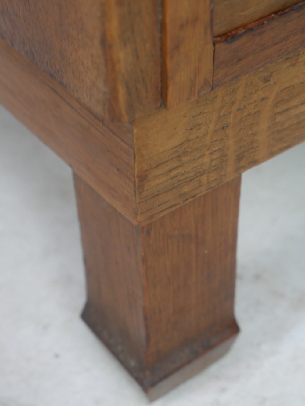 A mid-20th-century golden oak chest of drawers featuring three full-width drawers with contrasting dark wooden block handles and a low rear gallery rail. View V
