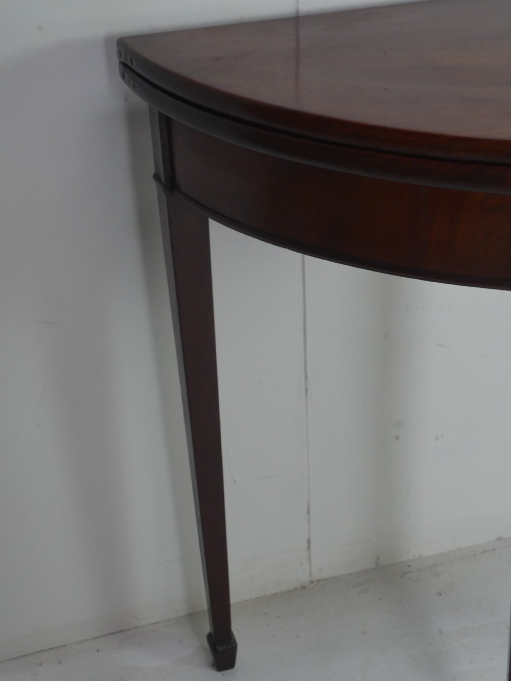 A Georgian mahogany demi-lune side table featuring a semi-circular top and four slender square tapered legs. View IV