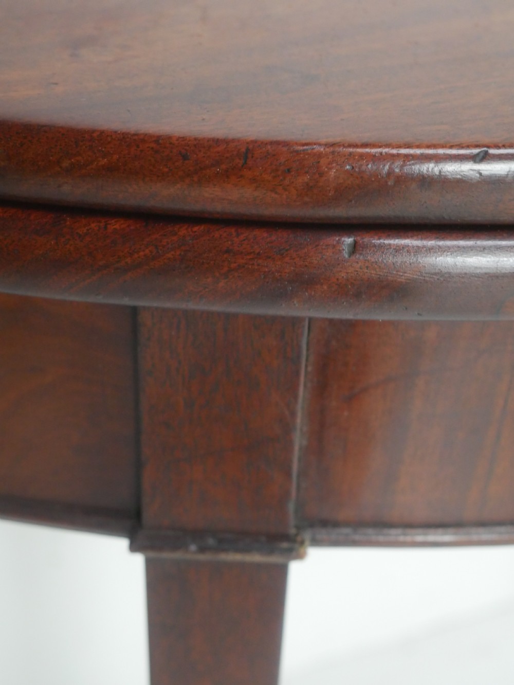 A Georgian mahogany demi-lune side table featuring a semi-circular top and four slender square tapered legs. View VI